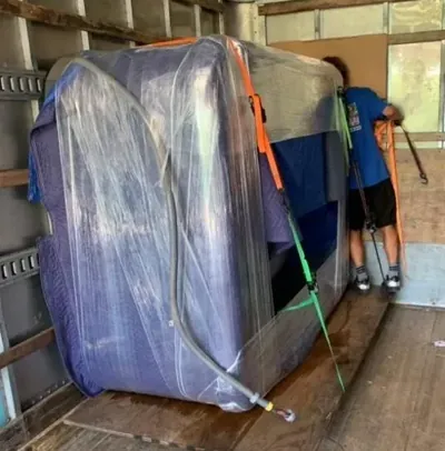 Wrapped heavy spa equipment secured inside a moving truck